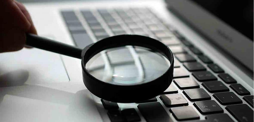 man performing seo with computer and magnifying glass